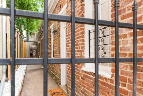 a view through a metal gate of a brick building at 610 Franklin - 5B - 1 Bed, 1 Bath, Heart of Downtown, Washer & Dryer in Natchez