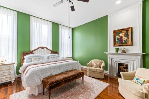 a bedroom with green walls and a bed and a fireplace at 610 Franklin - Upstairs - 1 Bed, 1 Bath, Sleeps 4, Walk to Downtown in Natchez