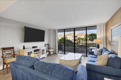 a living room with blue couches and a flat screen tv at 6415 Midnight Pass #202 in Siesta Key