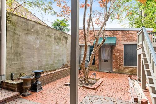 a brick wall and a tree in a courtyard at 610 Franklin - Downstairs - 2 Bed, 2 Bath, Heart of Downtown, Pet Friendly with fee in Natchez