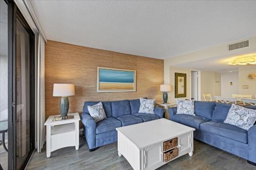 a living room with a blue couch and a table at 6415 Midnight Pass #202 in Siesta Key