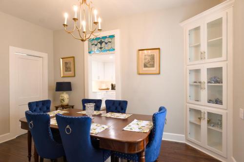 a dining room with a table and blue chairs at Borum House - 3 Bed, 2 & Half Bath, Full Kitchen, Heart of Downtown Natchez in Natchez