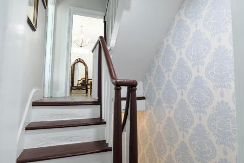 a hallway with a staircase with a mirror on the wall at Borum House - 3 Bed, 2 & Half Bath, Full Kitchen, Heart of Downtown Natchez in Natchez