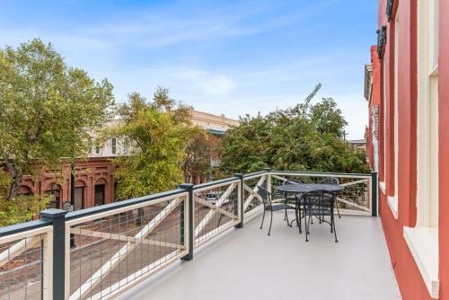 a balcony with a table and chairs on it at 610 Franklin - 3 Bed, 3 Bath, Duplex, Heart of Downtown in Natchez