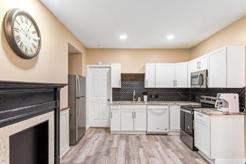 a kitchen with white cabinets and a clock on the wall at 610 Franklin - 3 Bed, 3 Bath, Duplex, Heart of Downtown in Natchez