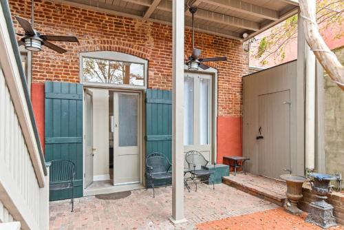 an outdoor patio with chairs and a brick wall at 610 Franklin - 3 Bed, 3 Bath, Duplex, Heart of Downtown in Natchez