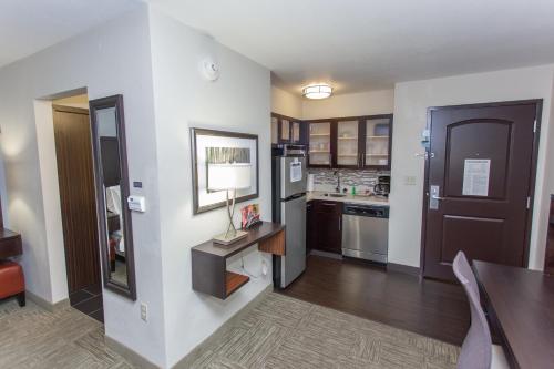 a large kitchen with a table and a refrigerator at Staybridge Suites Bowling Green by IHG in Bowling Green