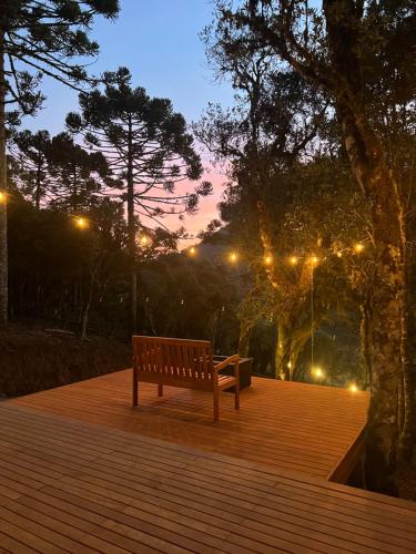 a park bench sitting on a wooden deck at night at Flor da serra in Urubici