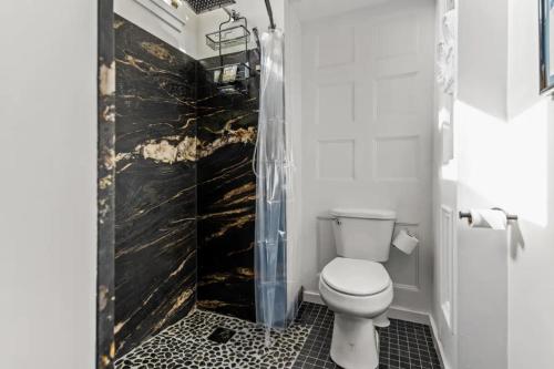 a bathroom with a toilet and a black wall at 1864 Little Brick - 1 Bed, 1 Bath, Full Kitchen, Pet Friendly with fee, Washer & Dryer in Natchez