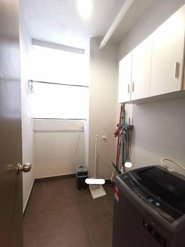 a small kitchen with a window and a refrigerator at Wincy's Cozy Retreat -The Mines in Serdang Lama