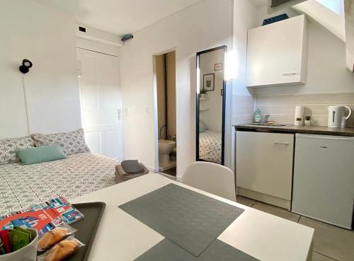Cette petite chambre comprend un lit et une cuisine. dans l'établissement Studio Rue Saint Jean, à Caen