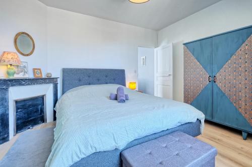 a bedroom with a large bed and a fireplace at T2 Art Déco proche Disney-Paris-Parking in Esbly