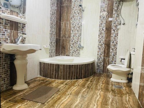 a bathroom with a sink and a tub and a toilet at golden mask pyramids view in Cairo