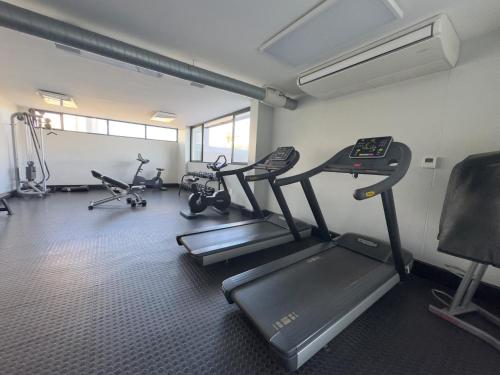 a gym with several treadmills and exercise bikes at Osheni City Center Apartment in Windhoek