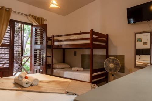 a bedroom with two bunk beds and a fan at Sunset Jeri Flat ate 10x in Jericoacoara