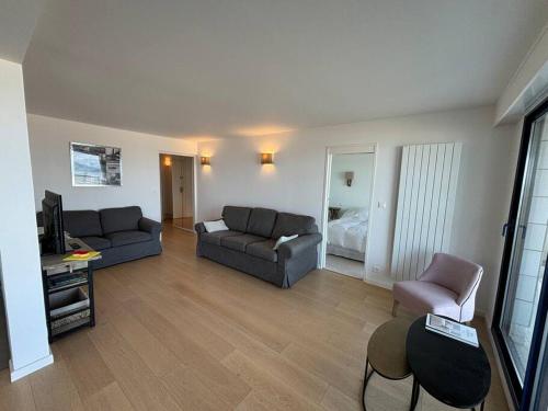 un salon avec deux canapés et une télévision dans l'établissement L Océan à vos Pieds Résidence Ouragan, à Le Touquet-Paris-Plage