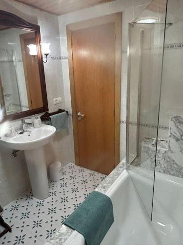 a bathroom with a tub and a sink and a shower at La casa Azul in Allariz