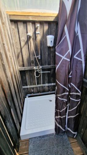 a bathroom with a shower with a toilet in it at SP camping Spāres Prieduļi in Nīca
