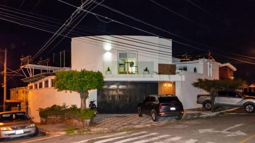 a white house with cars parked in front of it at Modern and Comfortable First Level Family Apt 4 in El Rodeo