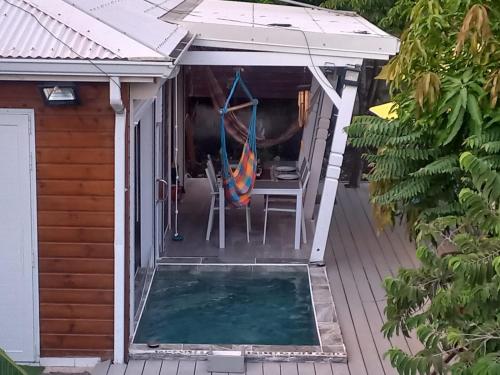 a patio with a table and a chair and an umbrella at Hibiscus Paradise in Vieux-Habitants