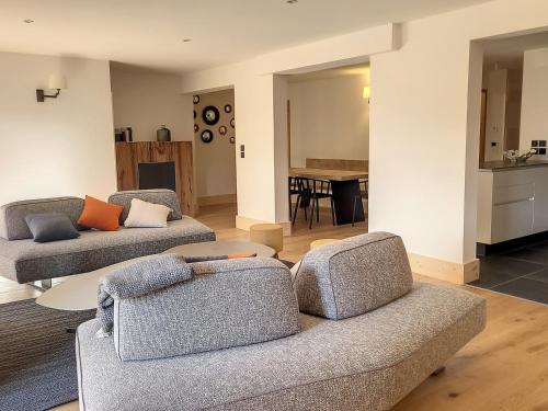 un salon avec deux canapés et une table dans l'établissement Appartement lumineux avec Spa, WIFI gratuit et équipement de sport à La Rosière - FR-1-275-179, à La Rosière
