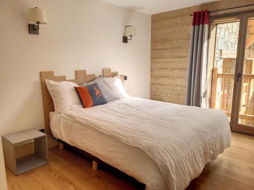une chambre avec un grand lit et une fenêtre dans l'établissement Appartement lumineux avec Spa, WIFI gratuit et équipement de sport à La Rosière - FR-1-275-179, à La Rosière
