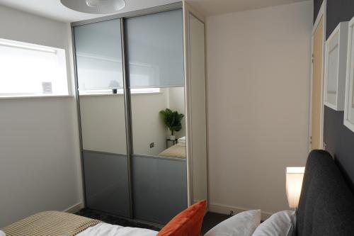 a living room with a large glass closet at Luxury Rooms - Pick a Room - Free Parking & Kitchen Access, Near Etihad Stadium, The Coop Live & Piccadilly Station, Manchester in Manchester