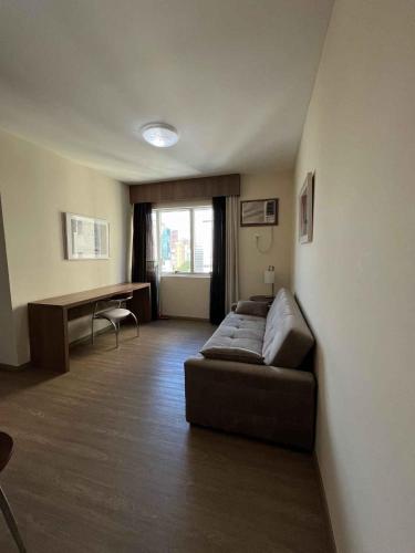 a living room with a couch and a desk at LK Barro Preto 8 in Belo Horizonte