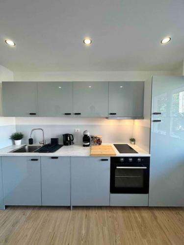a white kitchen with a sink and a stove at Blue pearl in Saint-Louis