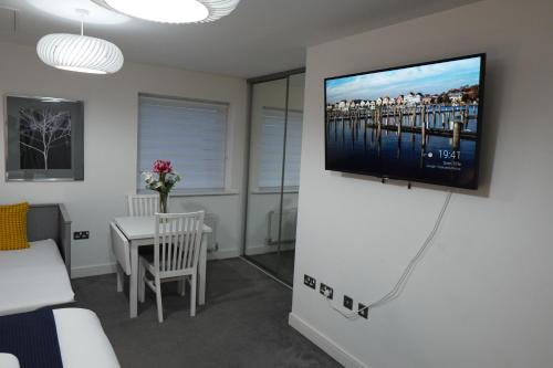 a living room with a flat screen tv on a wall at Luxury Rooms - Pick a Room - Free Parking & Kitchen Access, Near Etihad Stadium, The Coop Live & Piccadilly Station, Manchester in Manchester