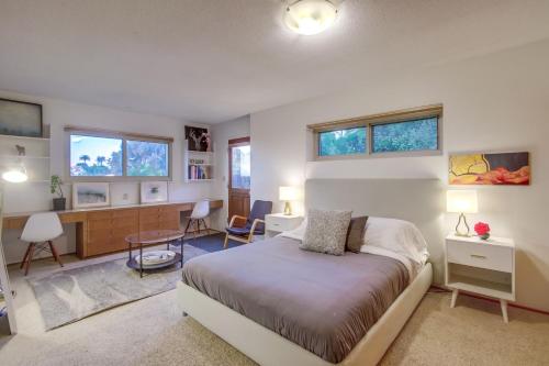 a bedroom with a bed and a desk and windows at Red Hawk Coastal Estate in San Diego