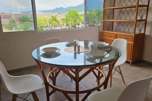a dining room with a table and chairs and a window at Familiar, amplio y con alberca in Puerto Vallarta