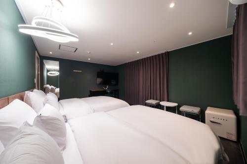 a hotel room with two white beds and chairs at Hotel May Yongsan in Seoul