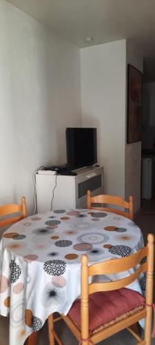 une table avec un tissu de table et deux chaises dans l'établissement Central studio ideal for hikers or skiers, à Brides-les-Bains