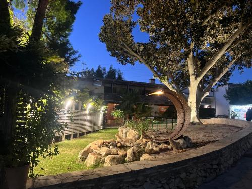 a garden with rocks and a tree at night at Villa Aurea in Ispica