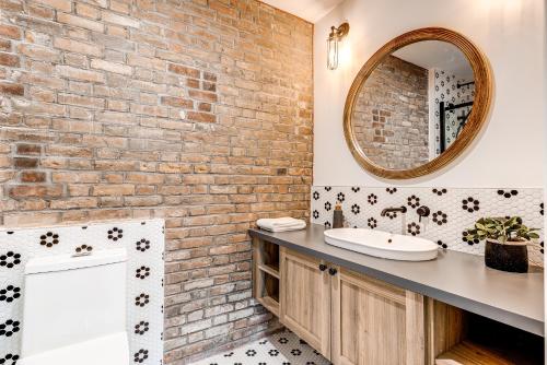 een badkamer met een wastafel en een bakstenen muur bij North House - Bohemian Vieux Quebec Two Bedroom in Québec
