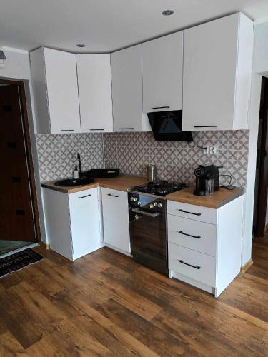 a kitchen with white cabinets and a stove top oven at apartament 30 m2 FOR YOU in Szczawno-Zdrój