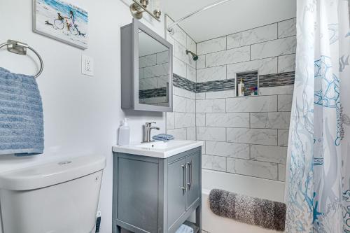 a bathroom with a toilet and a sink and a shower at Centrally Located Merritt Island Cottage with Deck! in Merritt Island