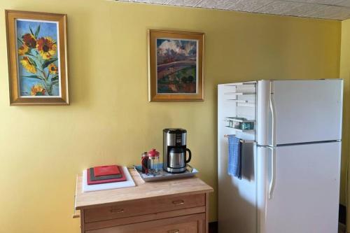 cocina con nevera y mesa con cafetera en Falls Farmstead 1865 Ellis House Cozy and Comfy Apt #1, en Ellsworth