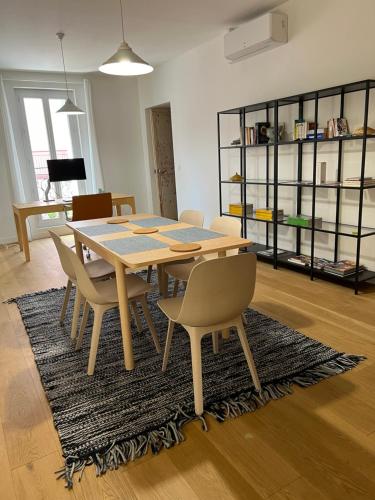 une salle à manger avec une table et des chaises sur un tapis dans l'établissement T4 atypique plein centre ville classé 3 étoiles, à Sète