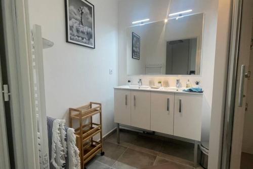 une salle de bain avec un lavabo et un miroir dans l'établissement Sérénité Raphaëloise, à Valescure