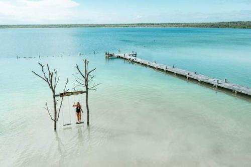 a person standing in the water next to a pier at Hostal Mulut Tulum in Tulum