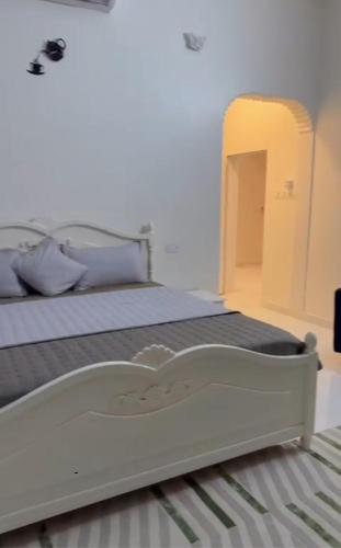 a white bed in a bedroom with a bed frame at GUEST HOUSEs OYSTERS in Al Ḩadd