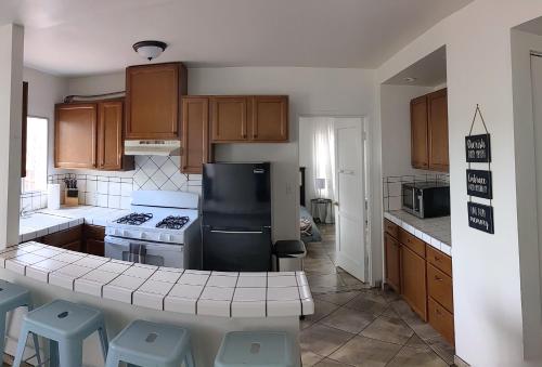 a kitchen with wooden cabinets and a black refrigerator at Centrally Located 2 Master Bedrooms to Explore all San Diego has to Offer in San Diego