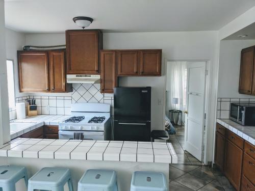 a kitchen with wooden cabinets and a stove top oven at Centrally Located 2 Master Bedrooms to Explore all San Diego has to Offer in San Diego