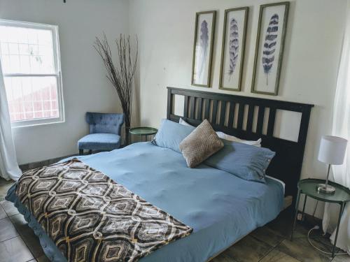 a bedroom with a bed with blue sheets and a chair at Centrally Located 2 Master Bedrooms to Explore all San Diego has to Offer in San Diego
