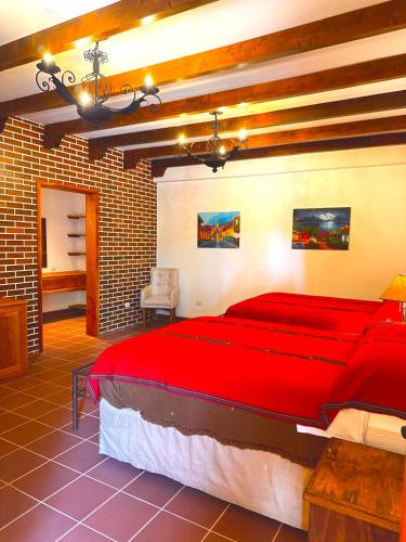 a bedroom with a large red bed in a brick wall at Hotel Jotam in Panajachel