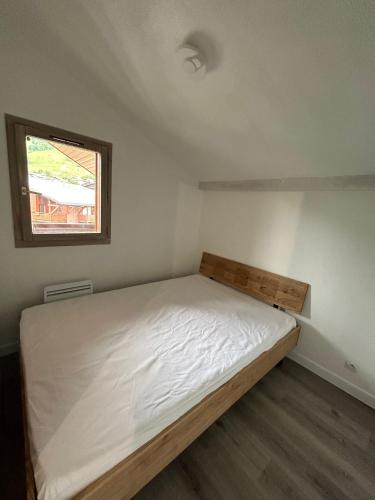 une petite chambre avec un lit et une fenêtre dans l'établissement Praz sur Arly - proche des pistes et de Megève, à Praz-sur-Arly