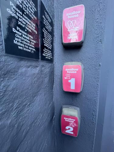 three parking meters on a wall with signs at Seaside Getaway @ Swallow House Suite #1 in Cape Town