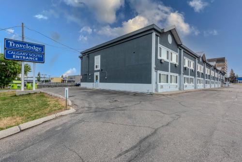a building on the side of a street with a sign at Travelodge by Wyndham Calgary South in Calgary